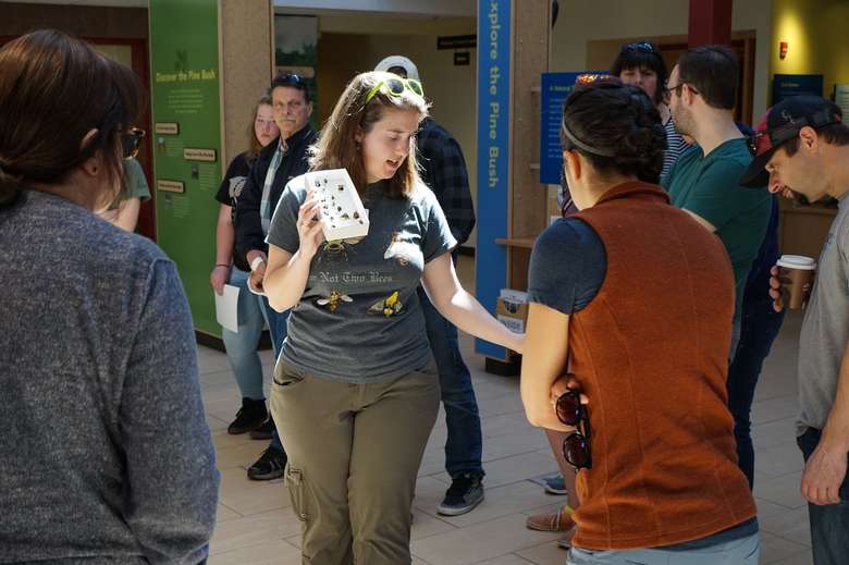 a woman surrounded by a group of people in a museum room