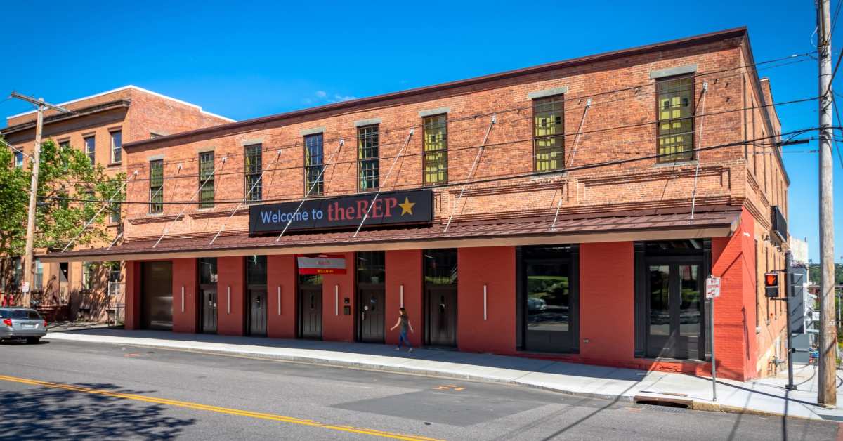 brick building with a sign on the front and red doors