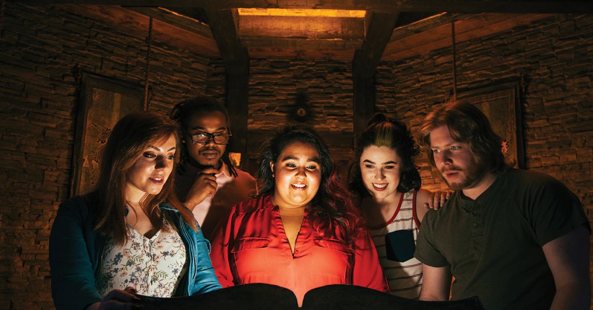 Group of people standing around a glowing book