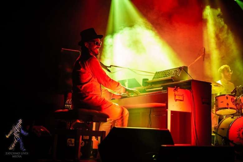 man at piano on stage, it's smokey