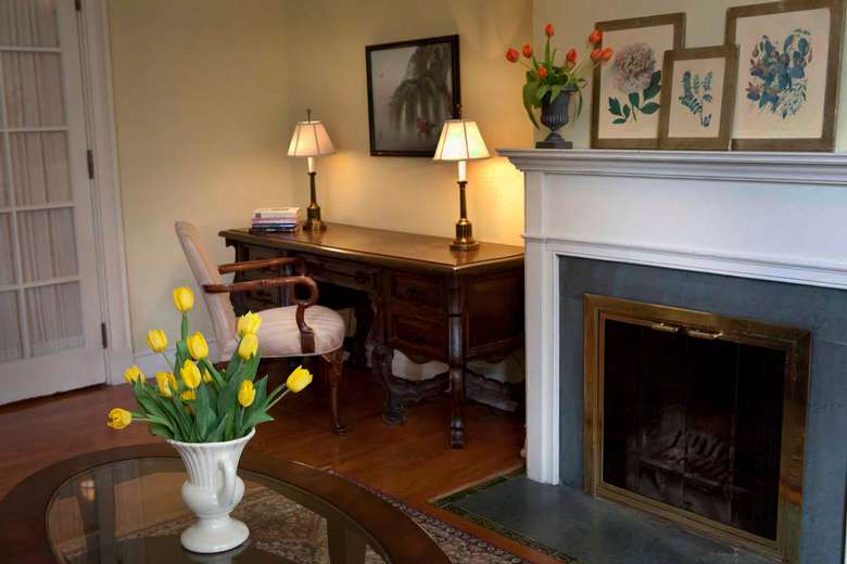 fireplace with a white mantle and a desk next to it