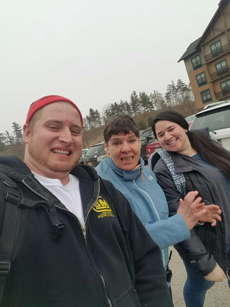 Three people smiling while they walk outside