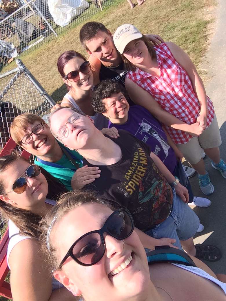 A group of smiling people outside on a sunny day