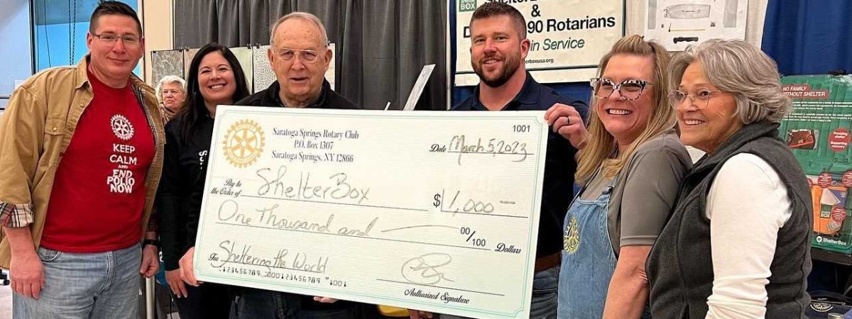 people holding up a large check