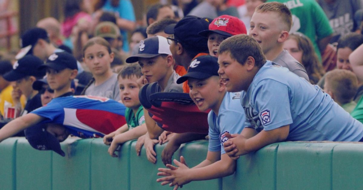 kids checking out baseball game from the wall