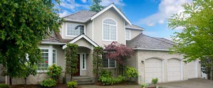large beige house with white trim and three car garage